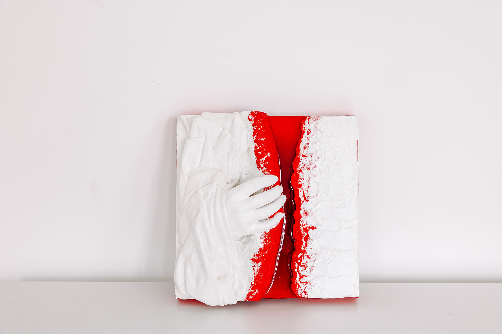 Zeitgenössisches Hochrelief „Aufbrechen“ (2024) von LadyMARIANN-Arts – plastisch modellierte weiße Oberfläche, geöffnet durch eine Hand, dahinter intensives Rot, Mixed Media Reliefkunst